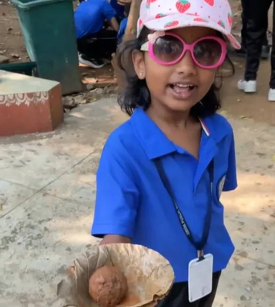 Child proudly holding a handmade seed ball at ChukkiMane