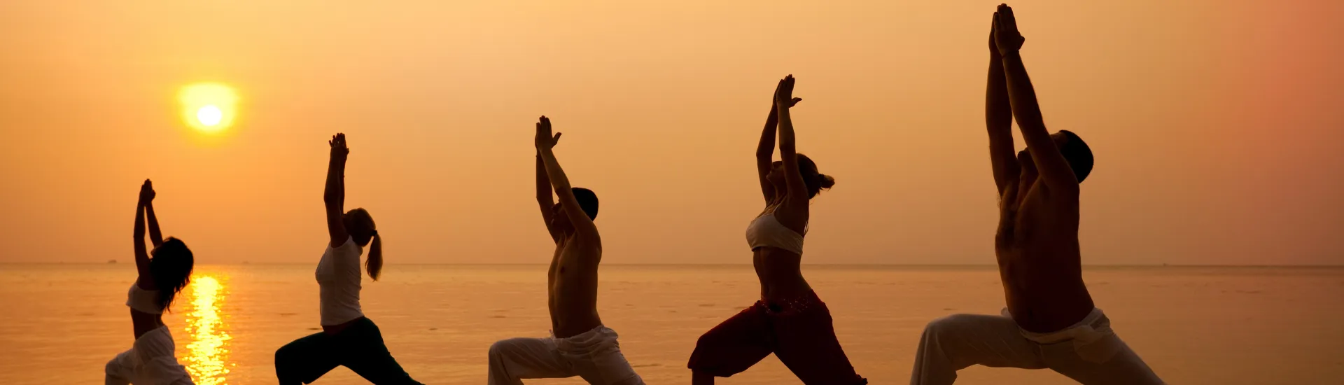 People practicing yoga outdoors surrounded by a peaceful natural landscape
