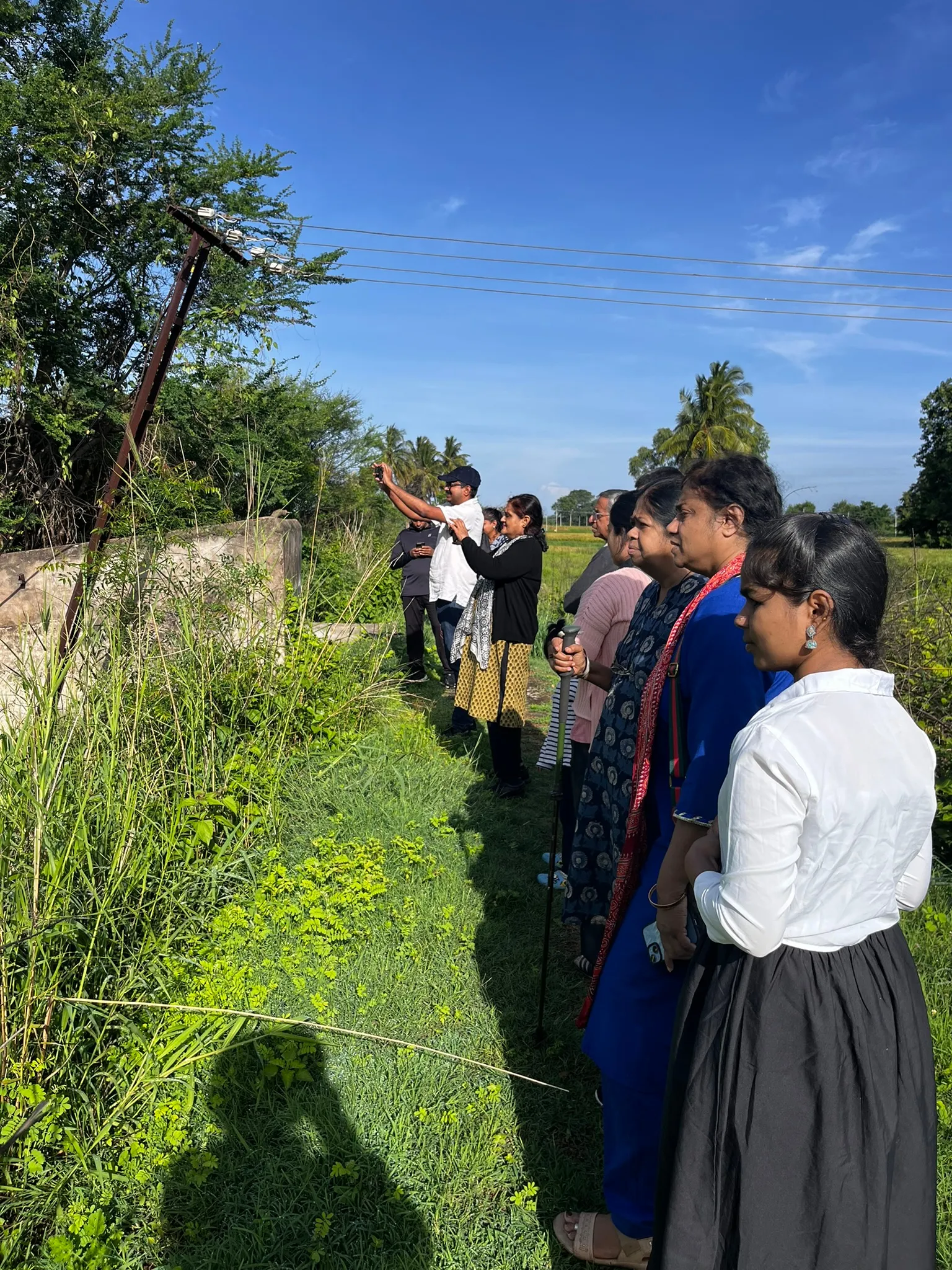 A group enjoying a bird watching session in fields near the Kaveri backwaters