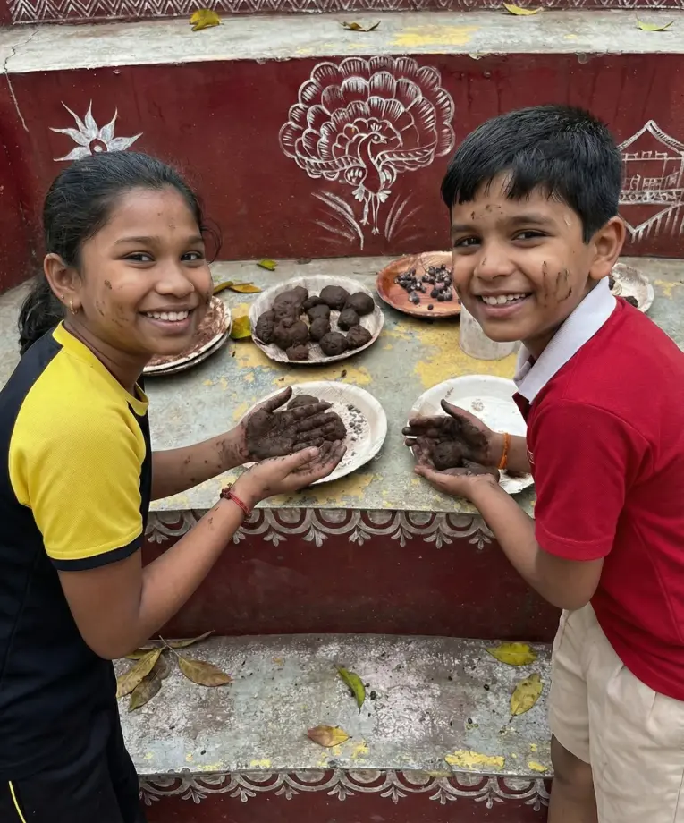 Children participating in a hands-on seed ball activity to learn about nature and planting