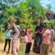 Children participating in an outdoor group learning activity surrounded by greenery at a nature camp