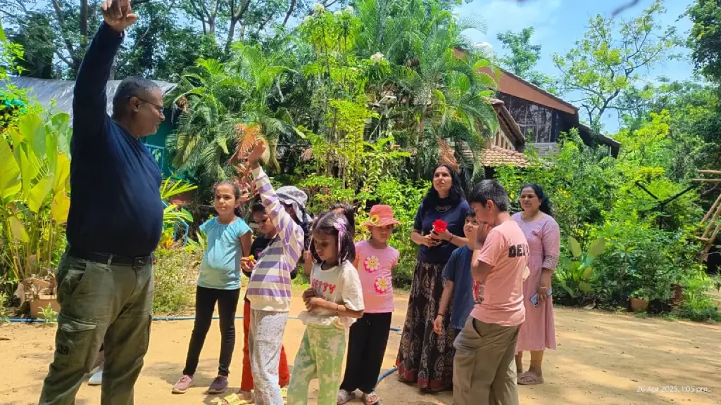 Children participating in an outdoor group learning activity surrounded by greenery at a nature camp